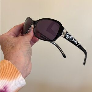 SunGear sunglasses. Black with etched white flowers on bows.